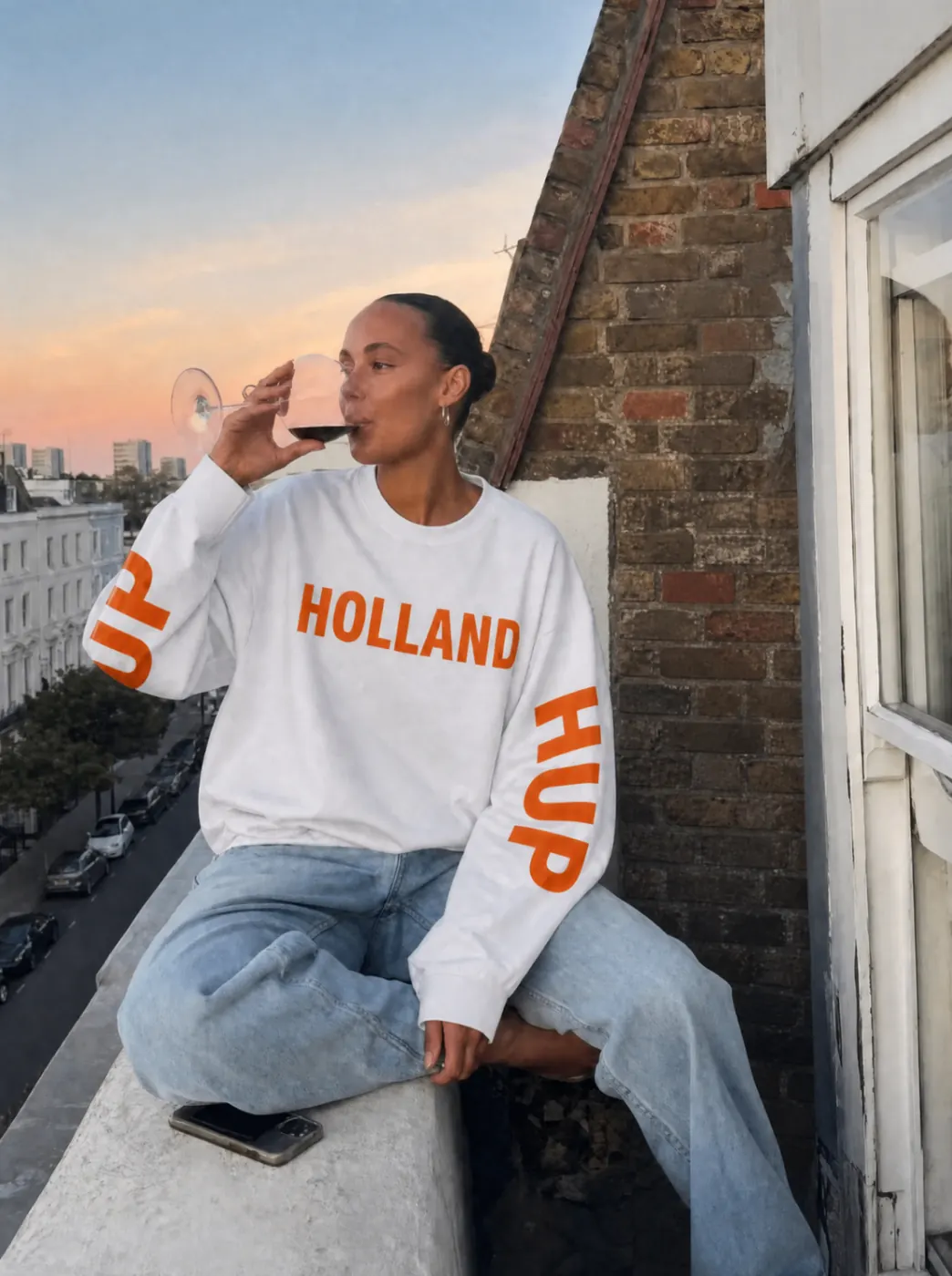 Witte Holland WK longsleeve gedragen op een balkon tijdens golden hour.