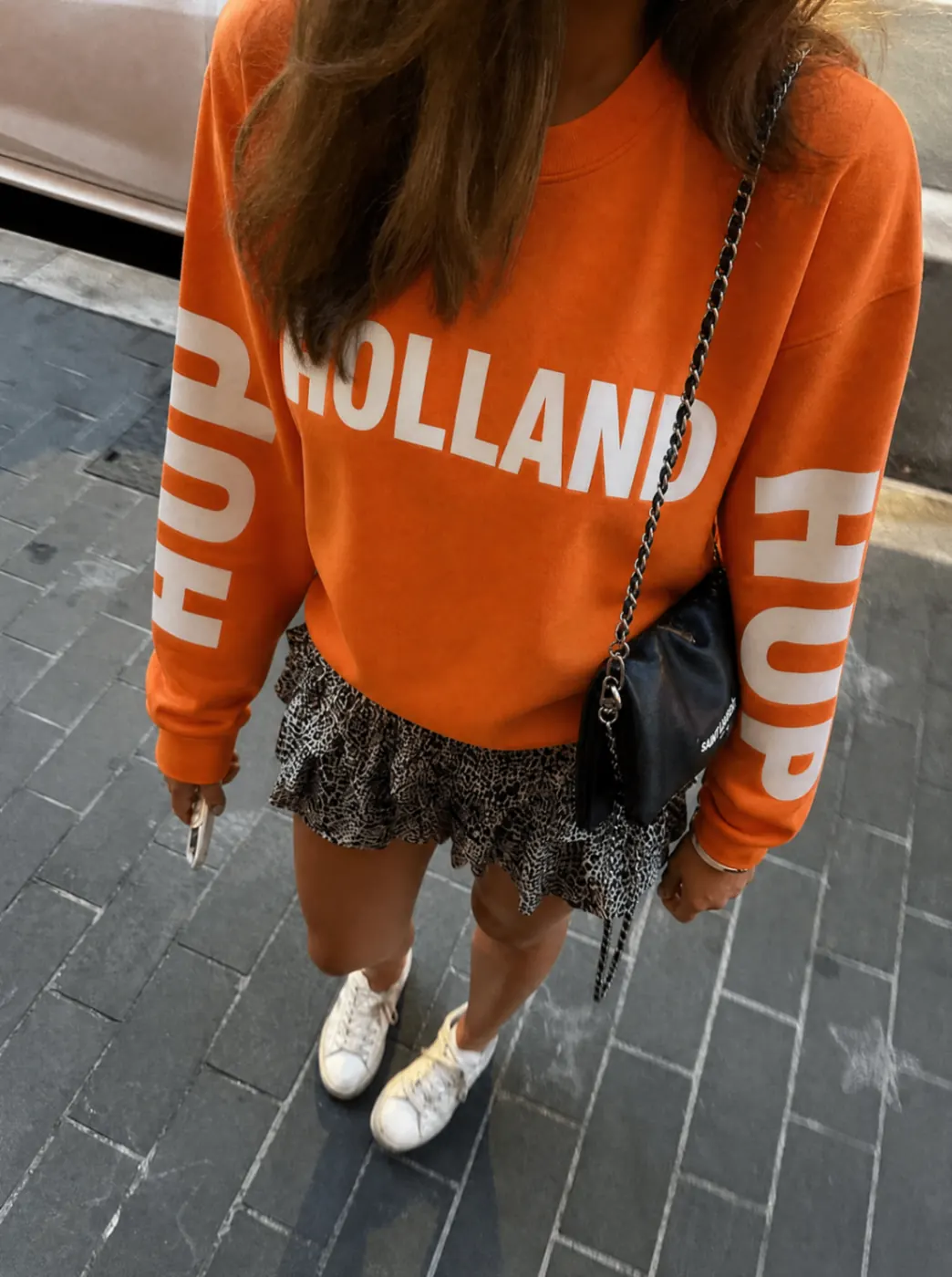 Oranje Holland WK longsleeve gestyled met rokje en sneakers voor een uitgesproken wedstrijddag look.