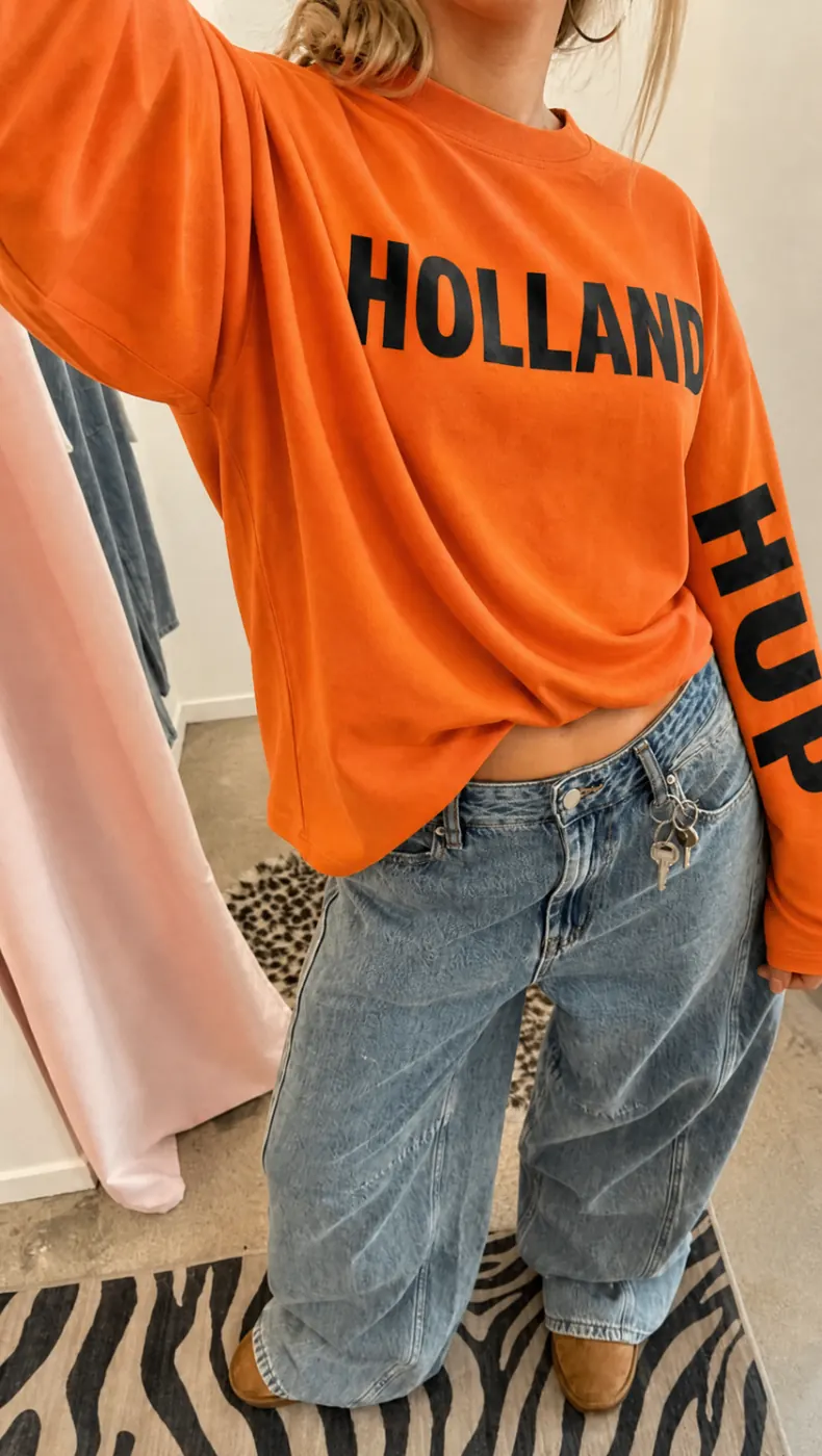 Oranje Holland WK sweater als close-up met wijde jeans voor een streetstyle look.