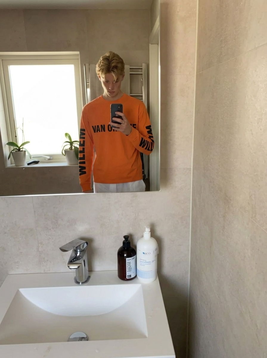 Felle oranje longsleeve 'Van Oranje' met witte broek voor heren — Koningsdag bathroom mirror selfie